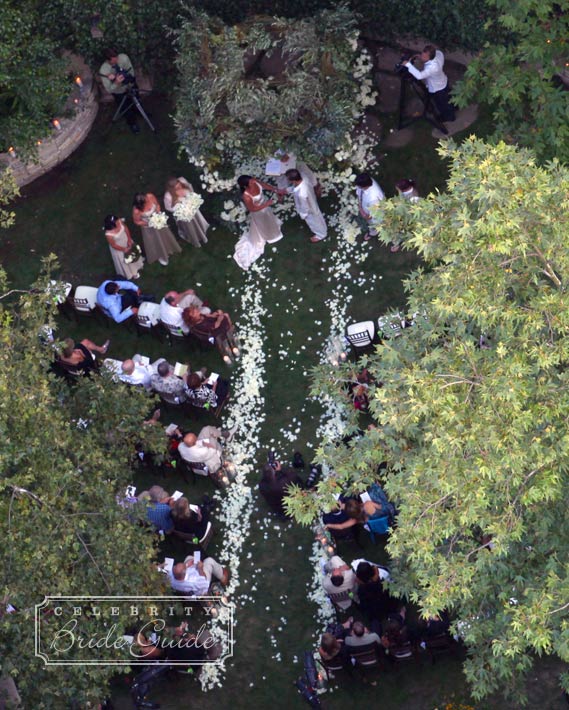 Guests watched the couple say their vows under an altar of white roses constructed by Mark's Garden.